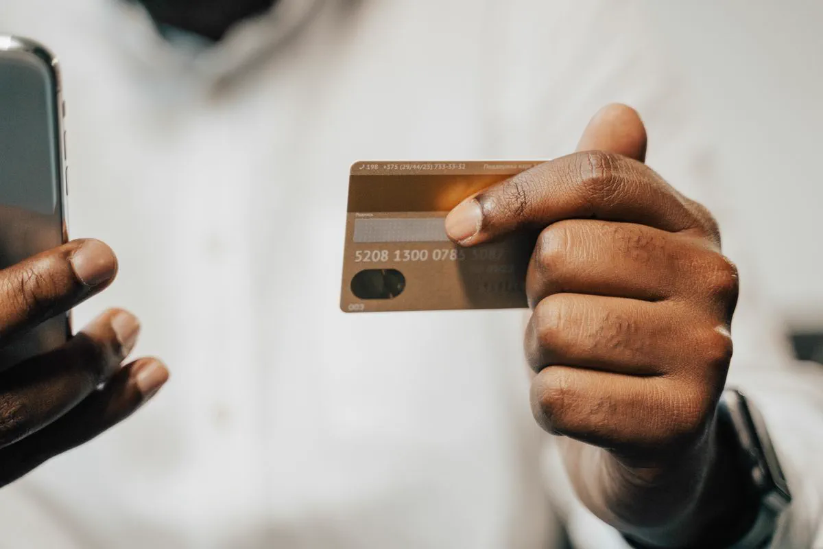 Someone holding a bank card and a smartphone